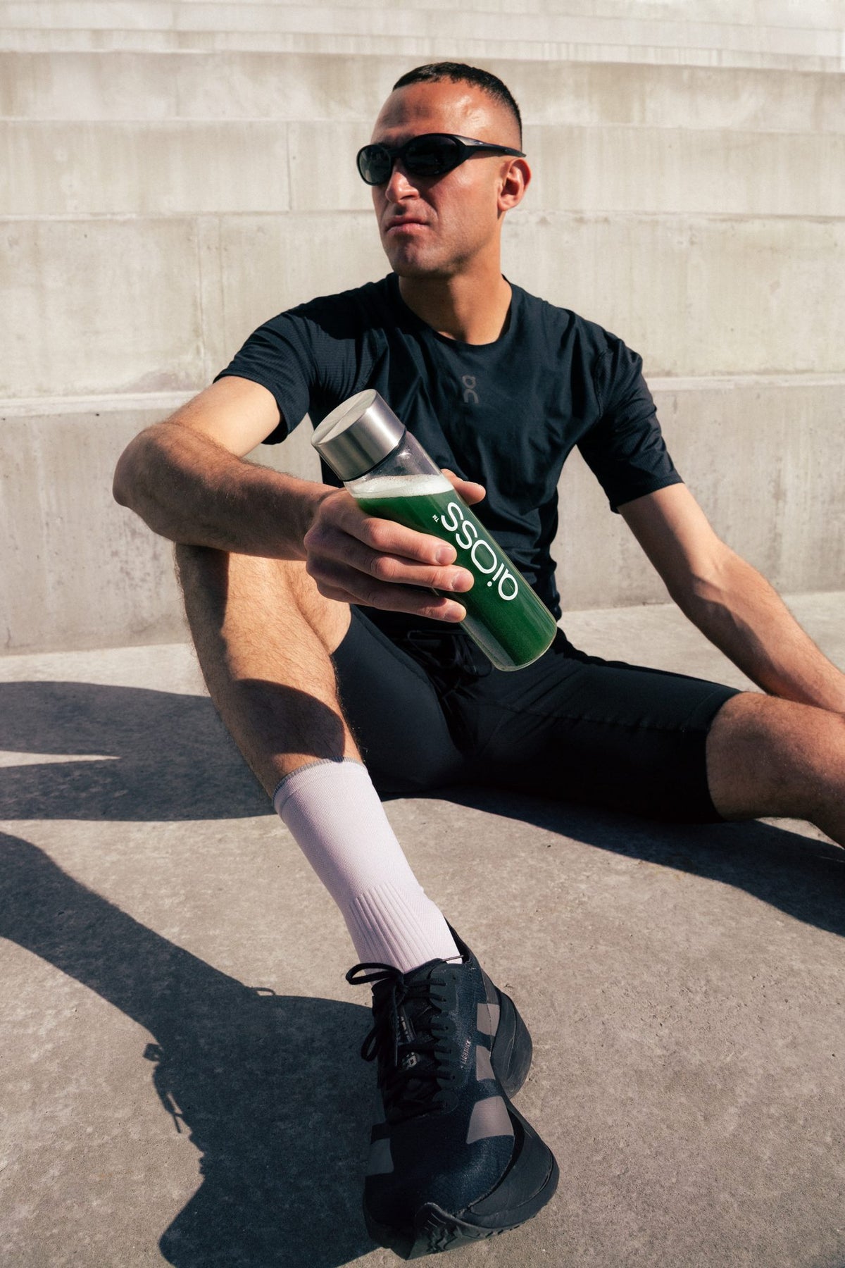 Athlete resting with an aioss bottle after training